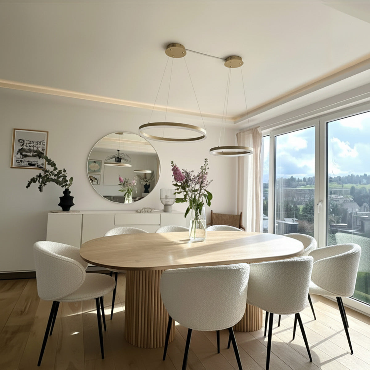 Oval wood dining table with slatted base and eight white boucle dining chairs.
