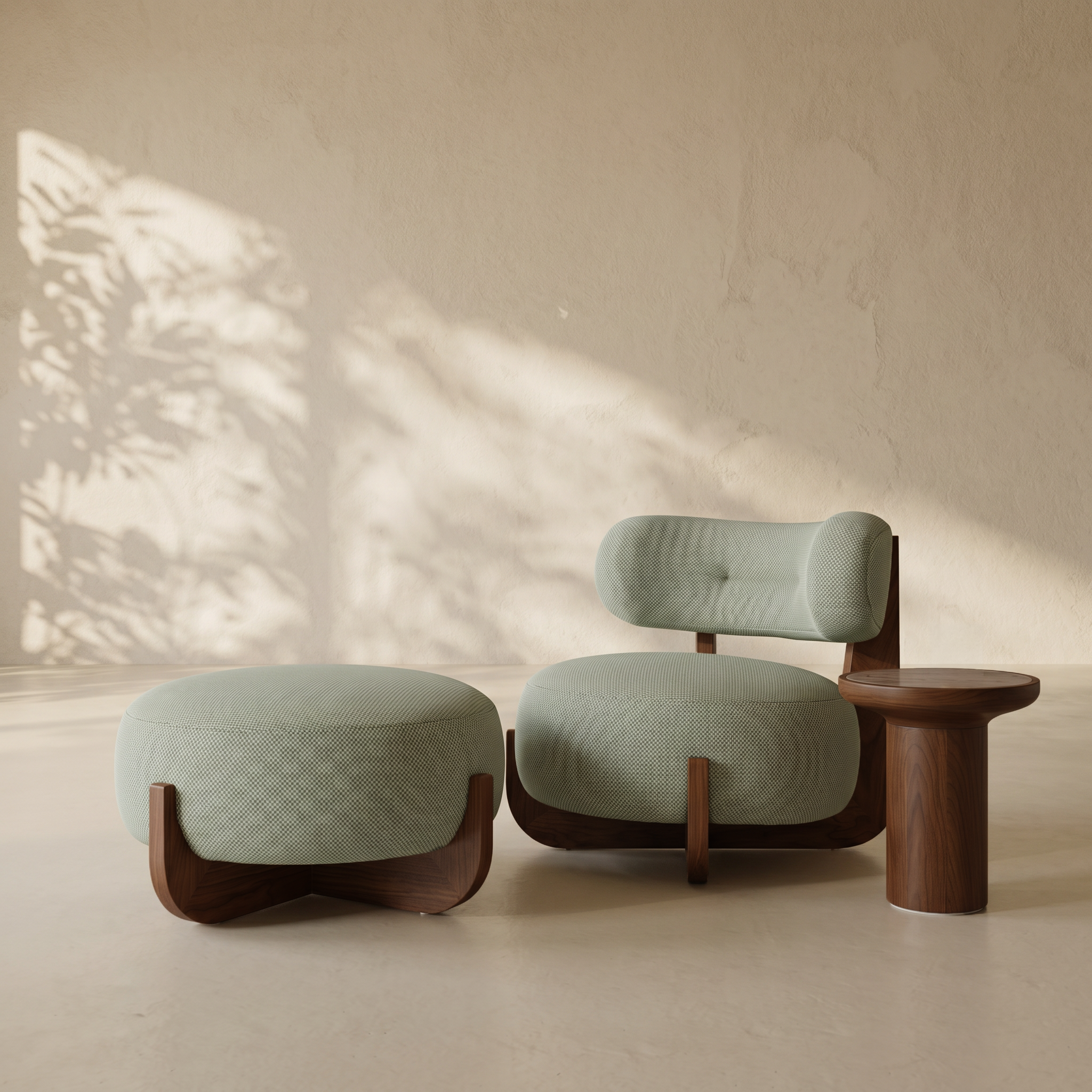 A modern lounge chair with a matching ottoman and a small side table, upholstered in a textured pale sage green fabric with dark wood bases, set against a warm beige wall with soft leaf shadows.