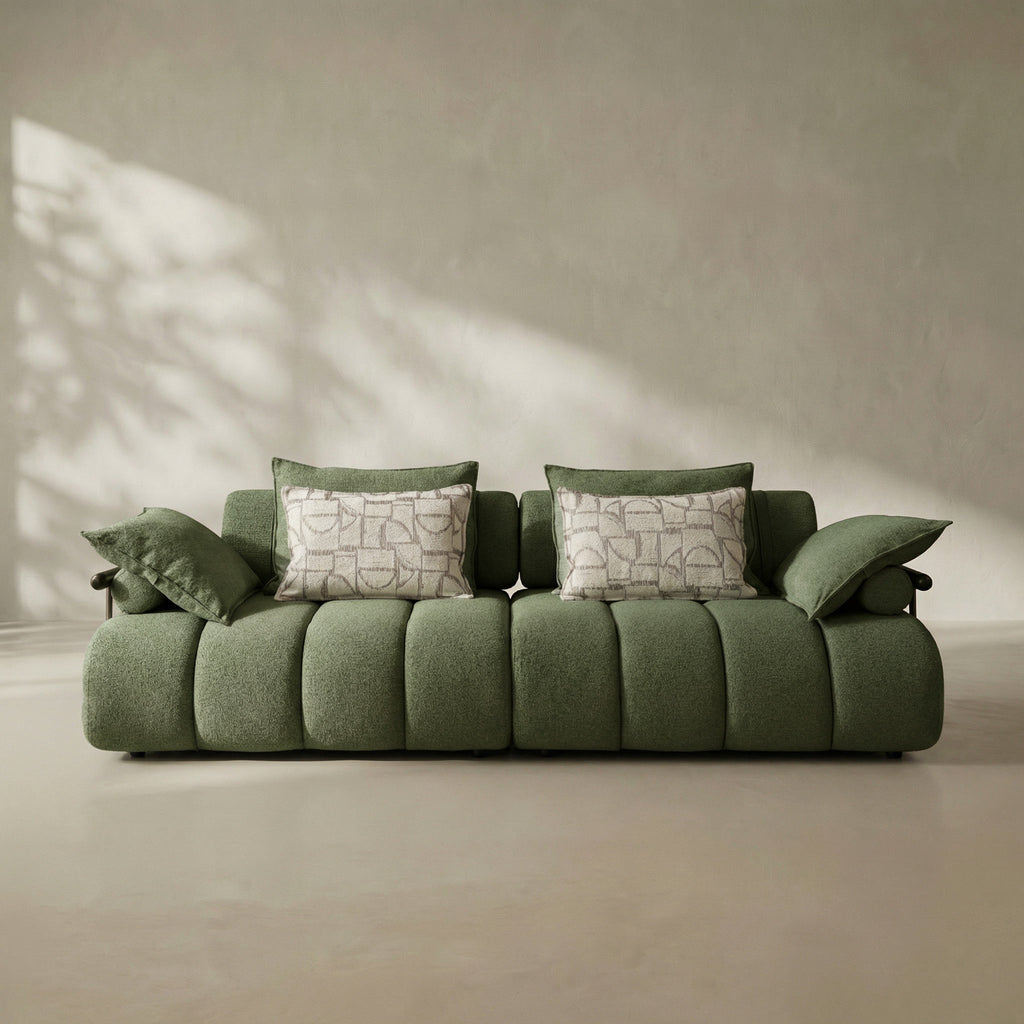 Green sofa with patterned cushions in a minimalistic room