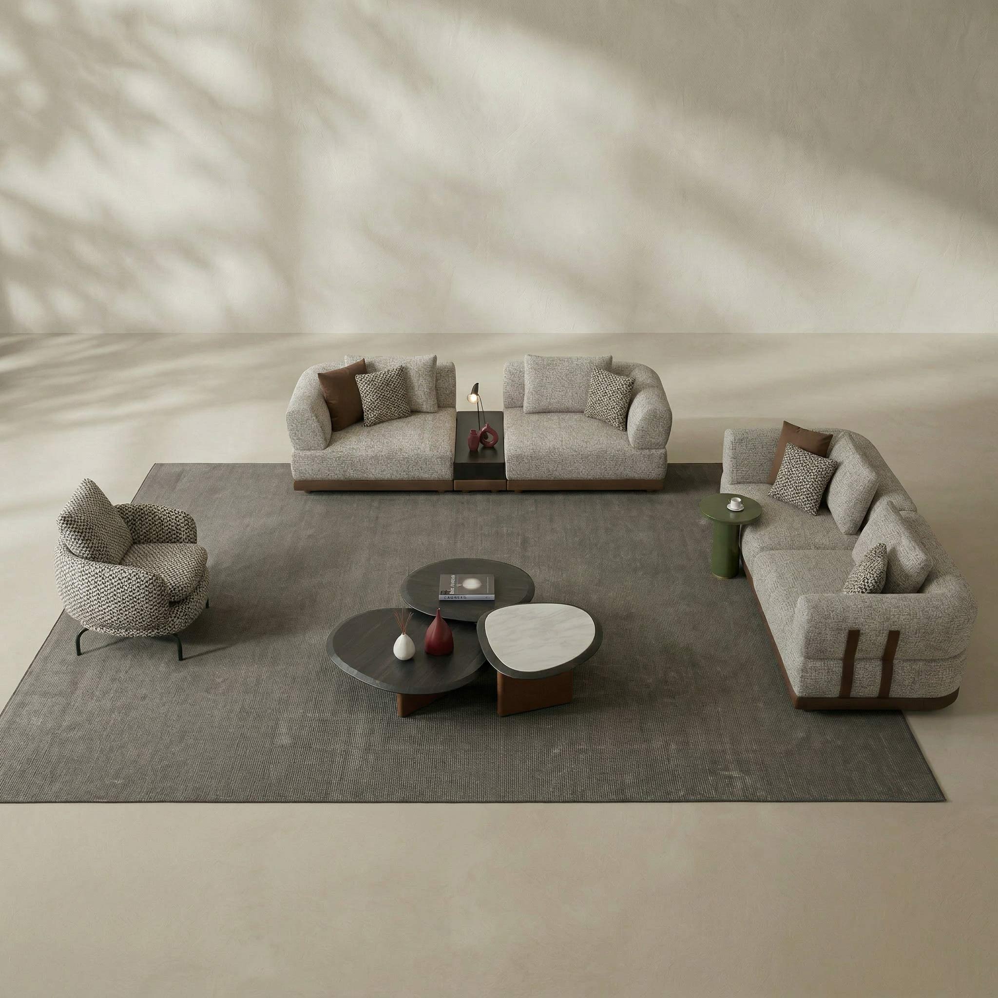 Modern living room with gray sofas, armchair, and coffee tables on a large rug.