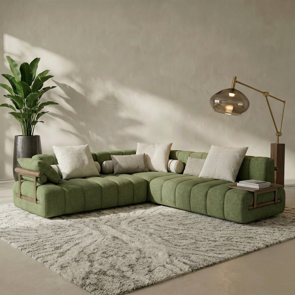 Green sectional sofa in a living room with a plant and lamp.