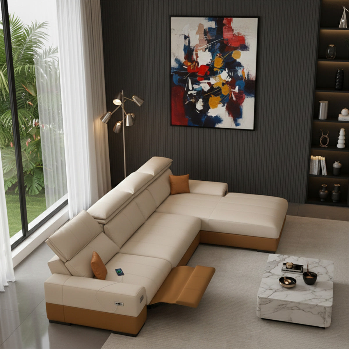 A close-up view of a two-toned cream and brown sectional sofa in an L-shape with a reclining end and a chaise lounge, set against a dark gray wall with a colorful abstract painting. A white marble coffee table is in the foreground.