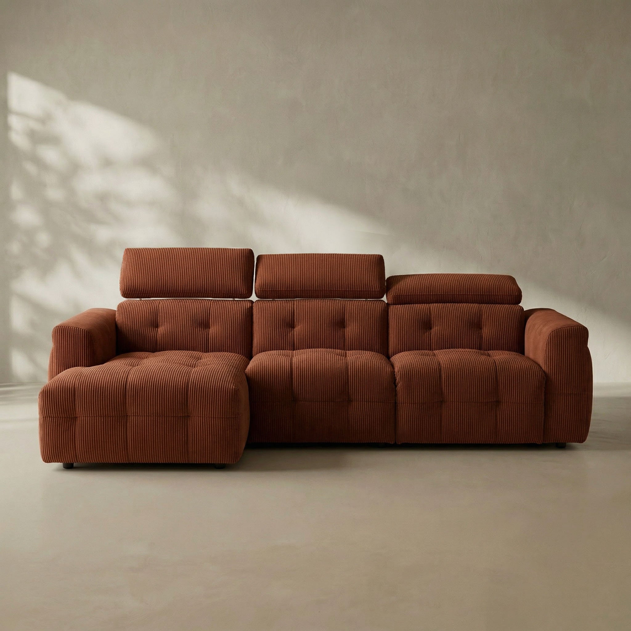 Brown sectional sofa in a minimalistic room with a neutral wall and floor.