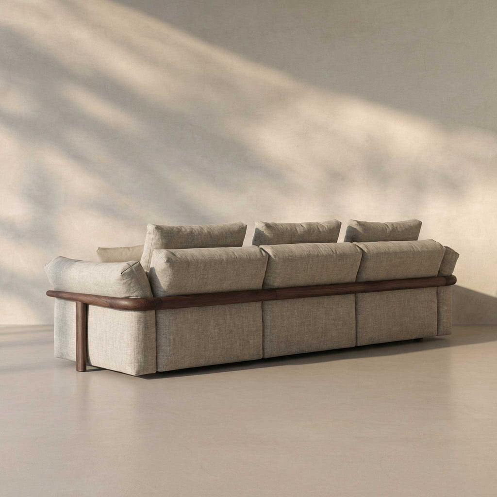 Beige sectional sofa with wooden frame in a minimalistic room.