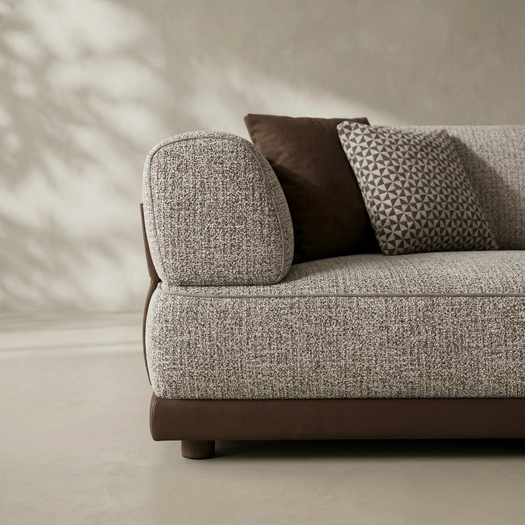 Gray textured sofa with brown cushions against a neutral wall