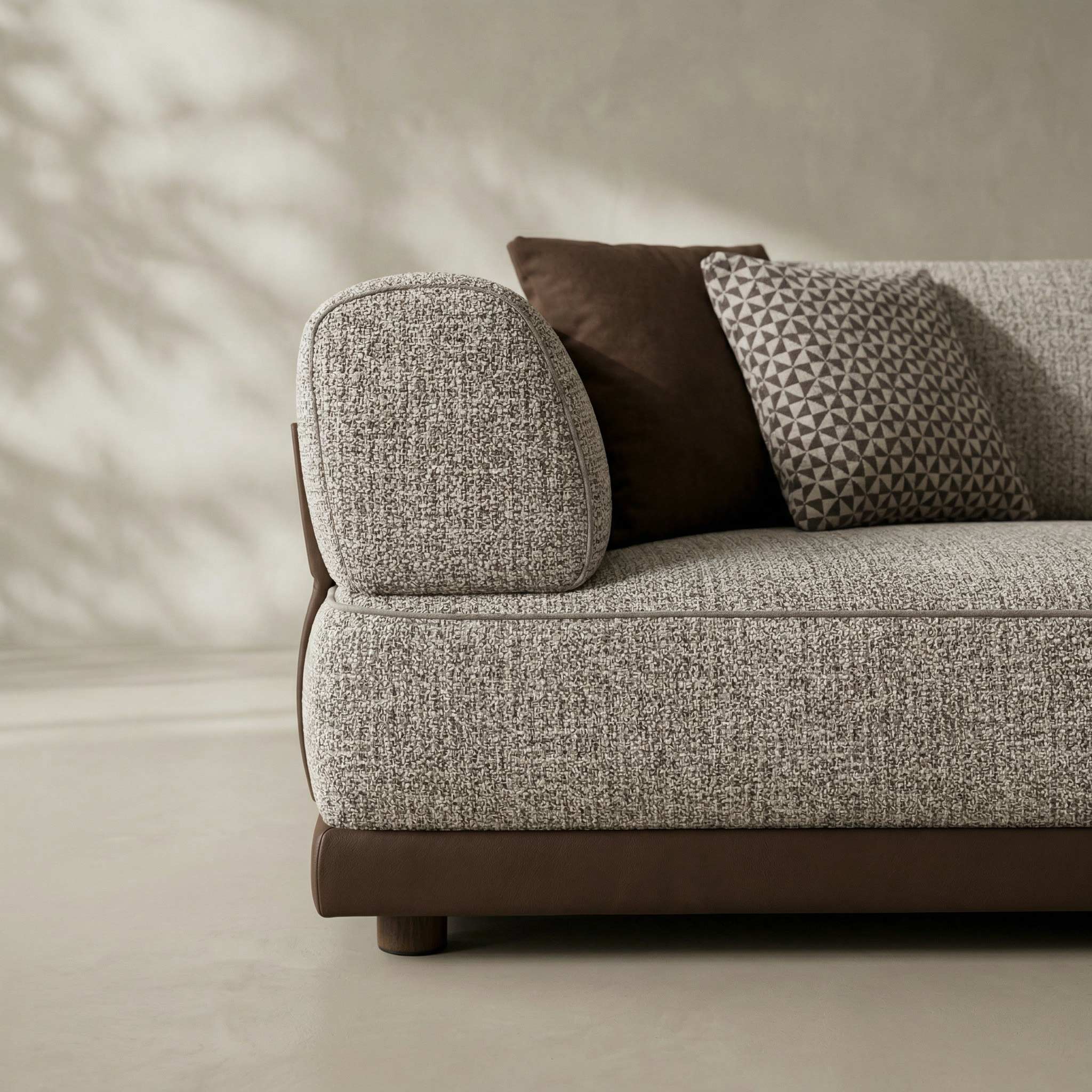 Gray textured sofa with brown cushions against a neutral wall