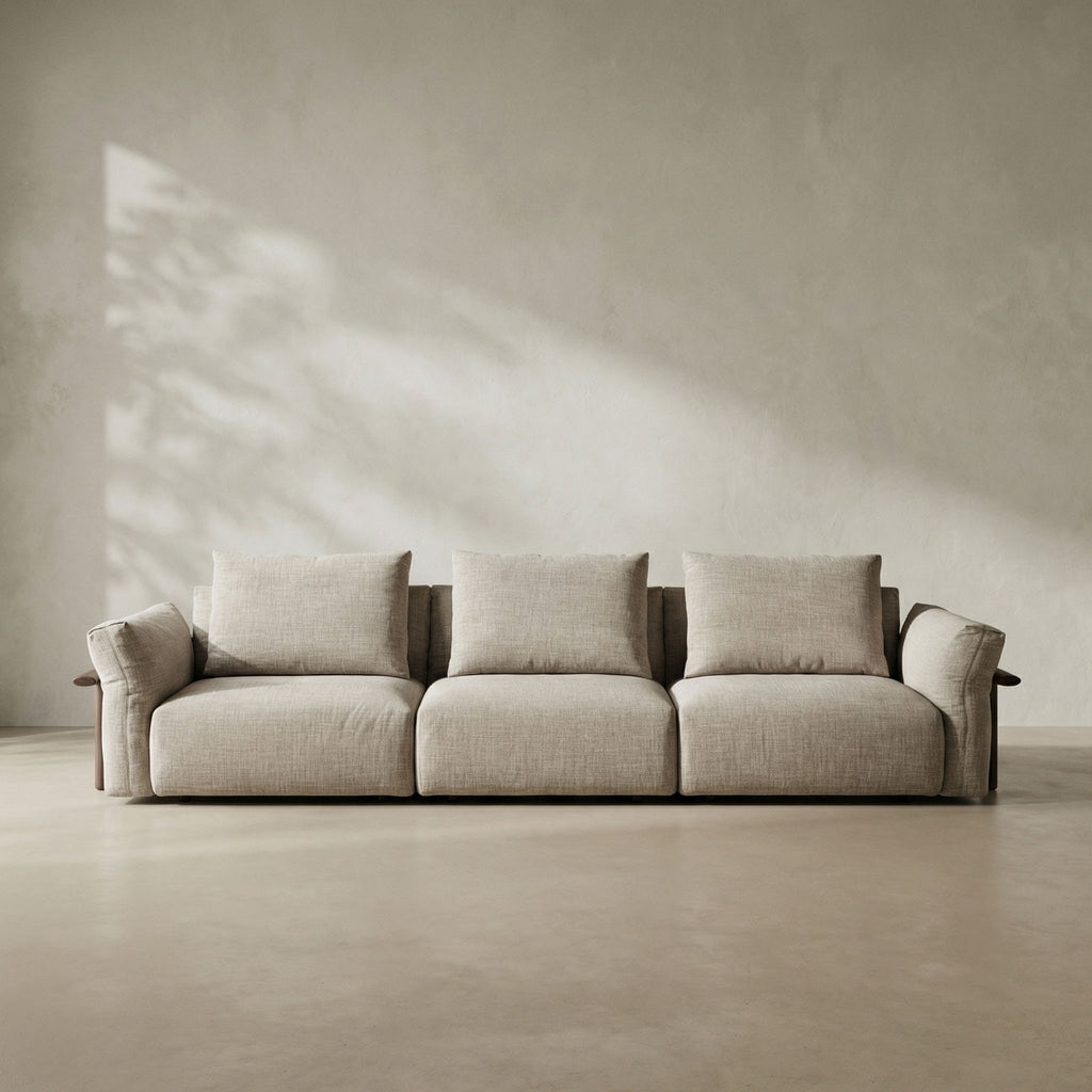 Beige sofa in a minimalistic room with a neutral wall and floor.