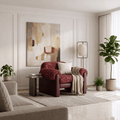A styled living room interior featuring a red textured armchair as the focal furniture piece, styled with a cream throw pillow, a beige knit throw blanket, a small side table, a floor lamp, and a large abstract painting on the wall.