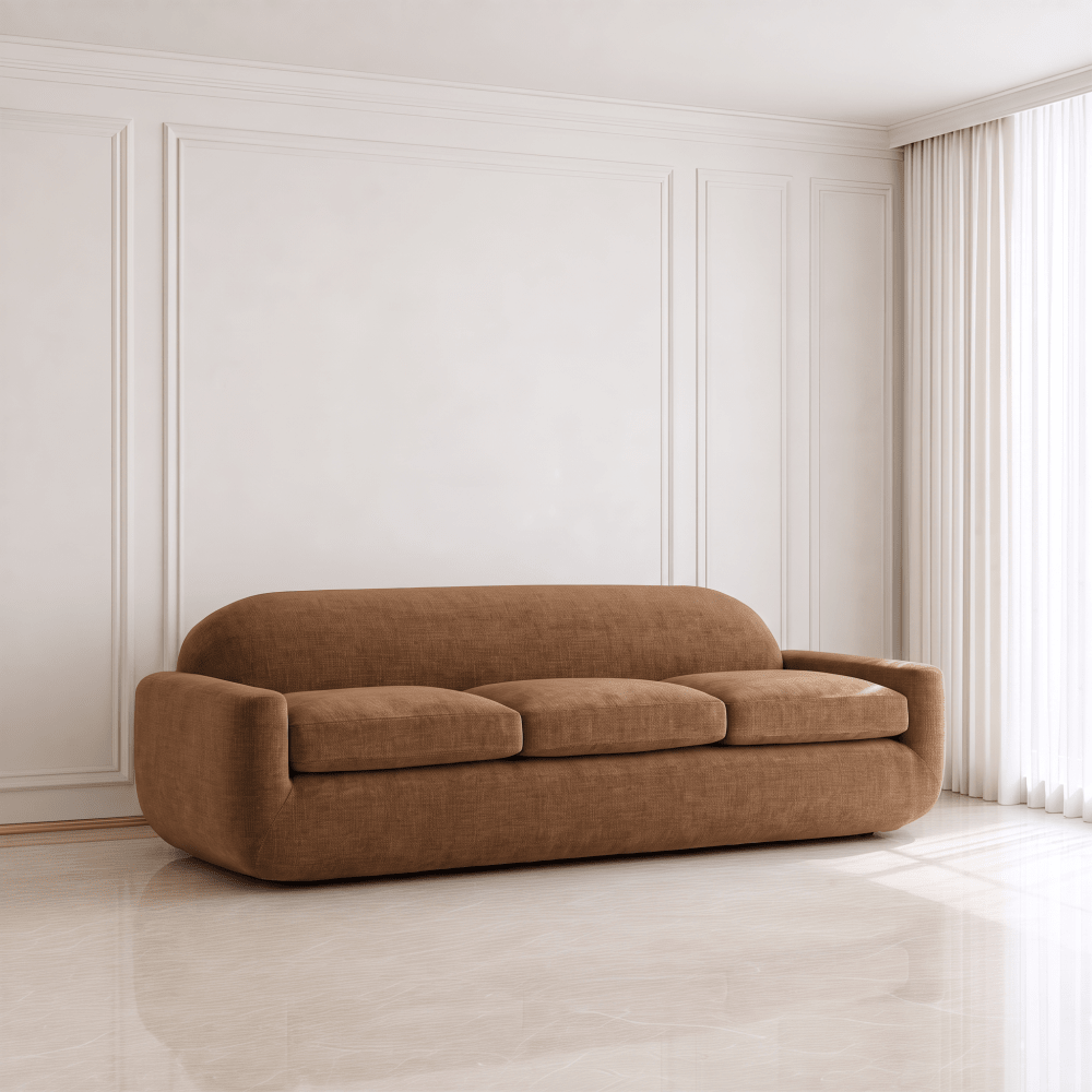 A modern three-seat sofa upholstered in a warm brown textured fabric, set against a minimalist white paneled wall and light-colored tiled floor.